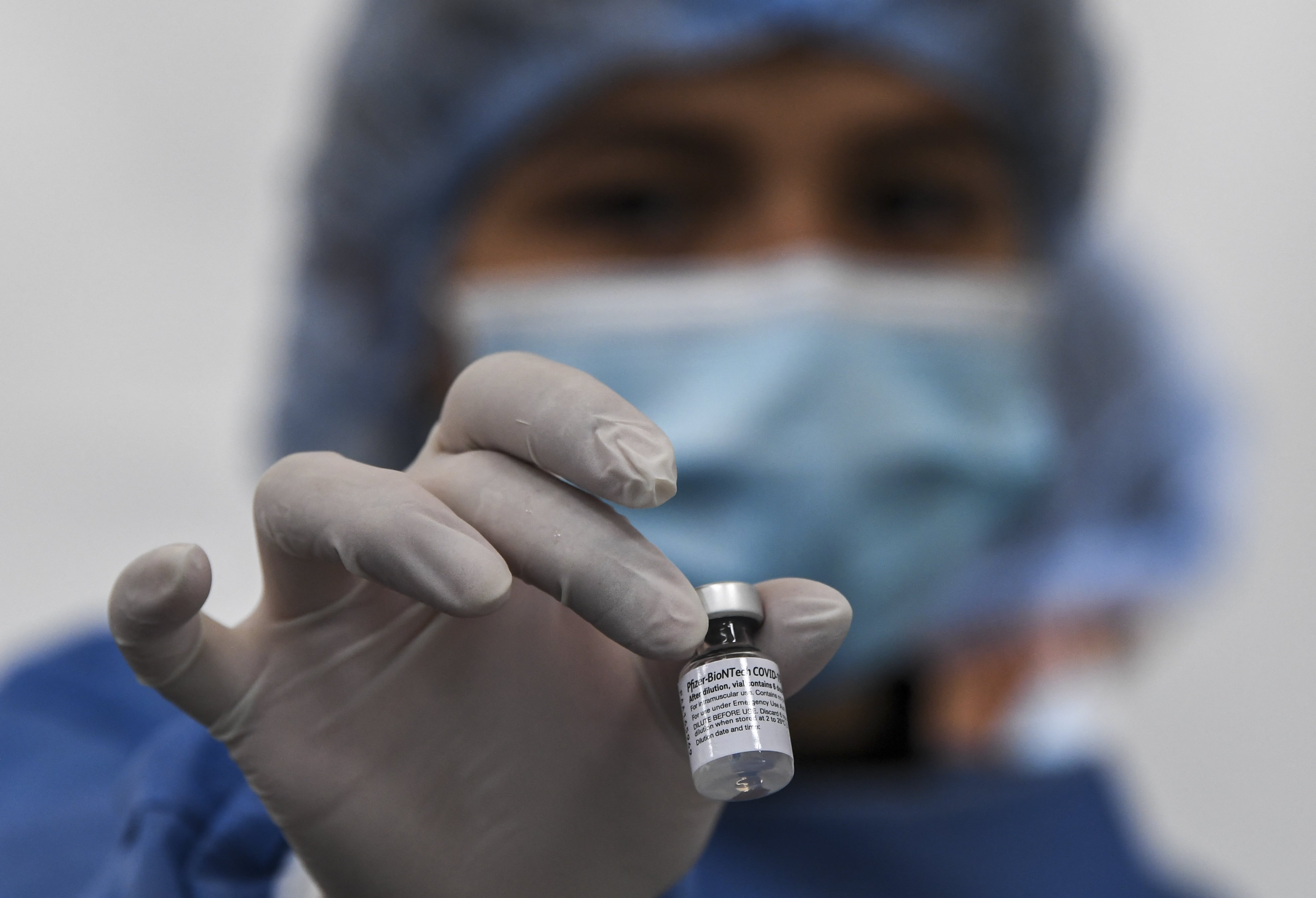 A nurse holds a vial of the Pfizer-BioNTech COVID-19 coronavirus vaccine at a shopping center in which people over 50 are vaccinated amid the ongoing novel coronavirus pandemic, in Bogota, on June 4, 2021. (AFP)