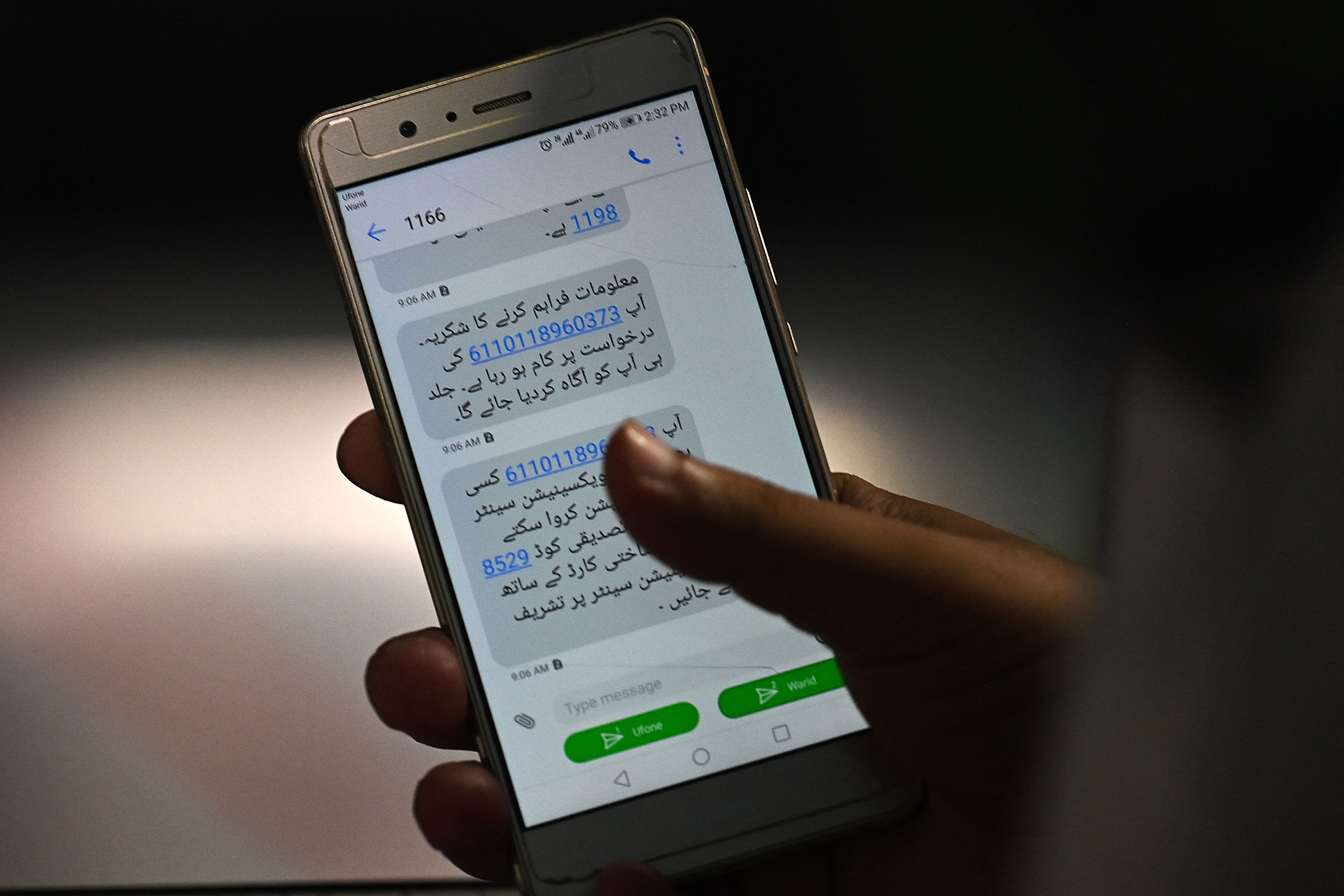 A man holds his cell phone to show his verification code to register to receive a dose of the Covid-19 coronavirus Sinopharm vaccine at a vaccination center in Rawalpindi on June 11, 2021. (AFP)