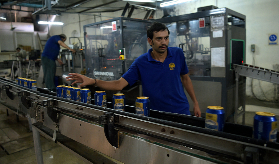 In this photograph taken on June 28, 2016, a Pakistani worker checks a line of aluminum cans at the Muree Brewery Company in Rawalpindi. (AFP)