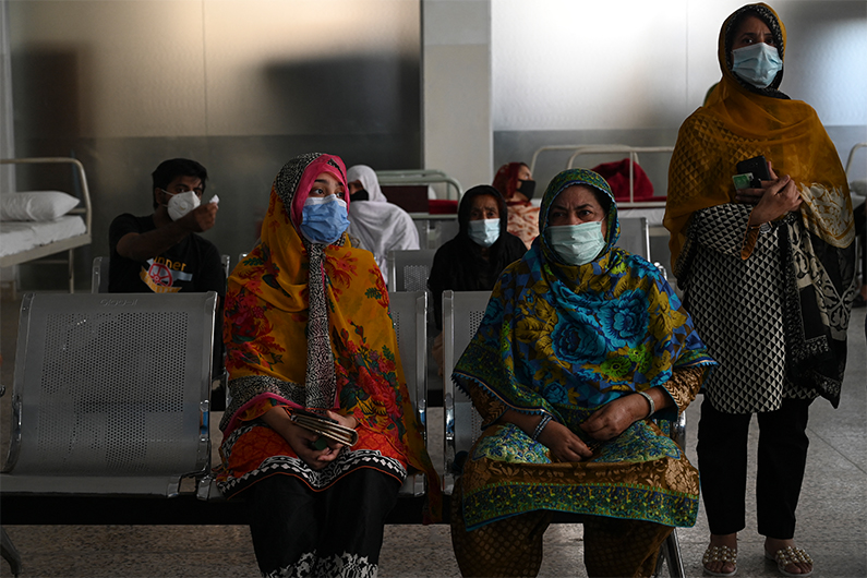 People wait for their turn to get a Covid-19 coronavirus Sinovac vaccine at the Red Crescent vaccination centre in Rawalpindi on May 24, 2021. (AFP)