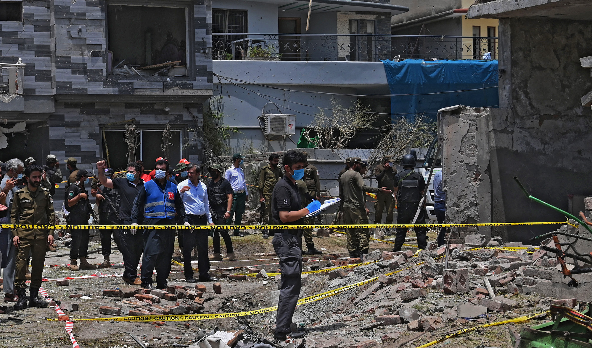 Security officials inspect the site of an explosion that killed at least three people and wounded several others in Pakistan's eastern city of Lahore on June 23, 2021. (AFP)