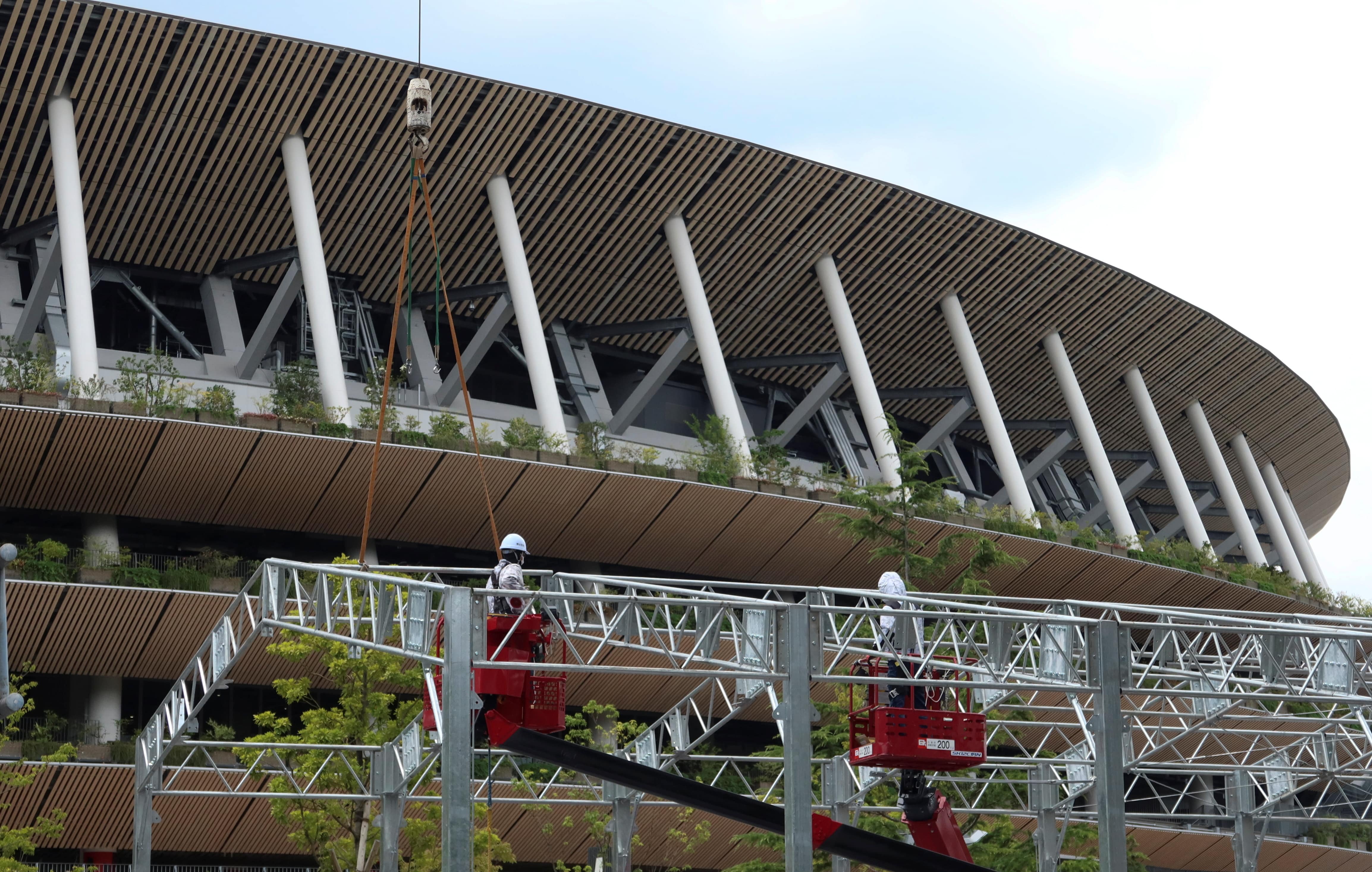 Workers build security checkpoint on the street in front of the National Stadium in preparation for the Tokyo 2020 Olympic Games in Tokyo, Japan June 26, 2021. (REUTERS)