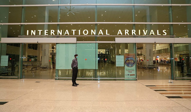 Airport Security Force (ASF) personnel wearing a mask stand guard at the International arrivals area at Islamabad International Airport, Pakistan, on May 5, 2020. (Photo courtesy: Ministry of Overseas Pakistanis & HRD/Twitter)