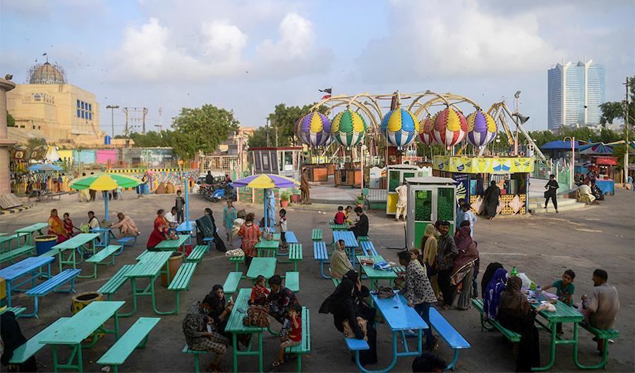 People rest at eat at a funfair after the government eased restrictions to curb the spread of coronavirus restrictions in Karachi on June 15, 2021. (AFP)