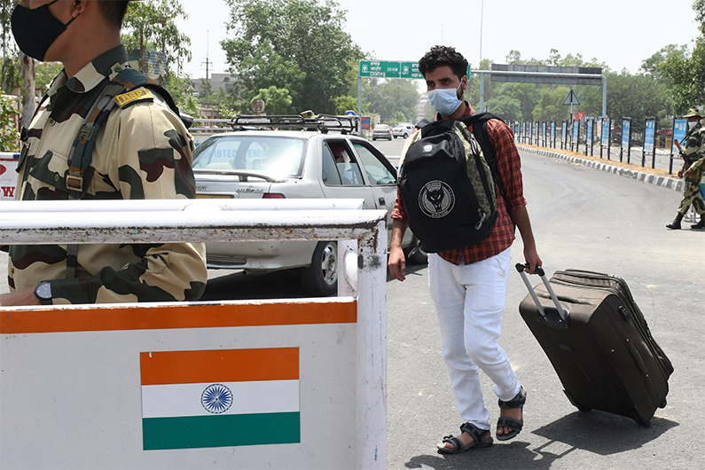 An Indian national returns after being stranded due to the Covid-19 coronavirus pandemic, at the India Pakistan-Wagah Border Post, some 35 km from Amritsar on June 28, 2021. (AFP)