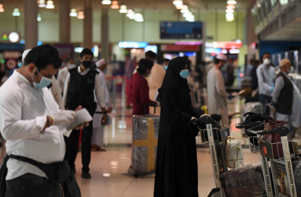 Members of a Pakistani family wait at the Dubai International Airport before leaving the Gulf Emirate on a flight back to their country, on May 7, 2020, amid the novel coronavirus pandemic crisis. (AFP/File)