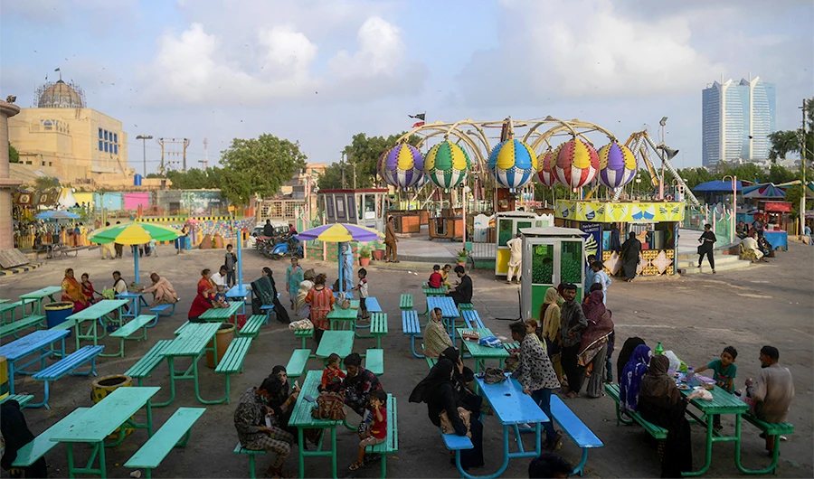 People rest at eat at a funfair after the government eased restrictions to curb the spread of coronavirus restrictions in Karachi on June 15, 2021. (AFP)