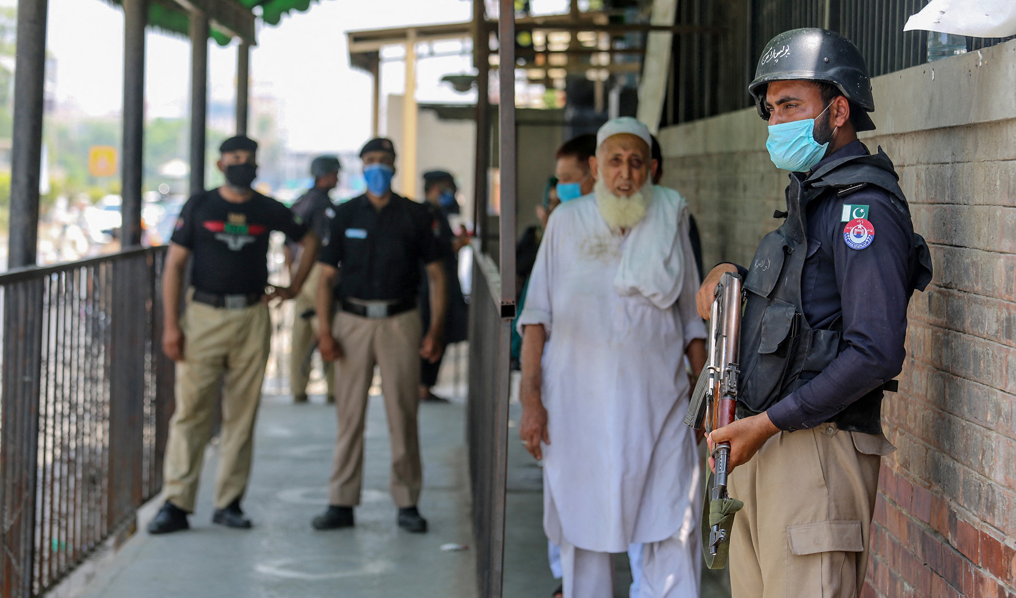Security personnel (L and R) stand guard outside the district court building following the killing of a man allegedly accused of blasphemy in Peshawar on July 29, 2020. (AFP/File)
