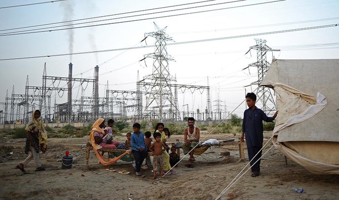 A family sits by its tent in front of DPS thermal power station in Muzaffargah, Punjab Province Pakistan, on September 5, 2010. (AFP)