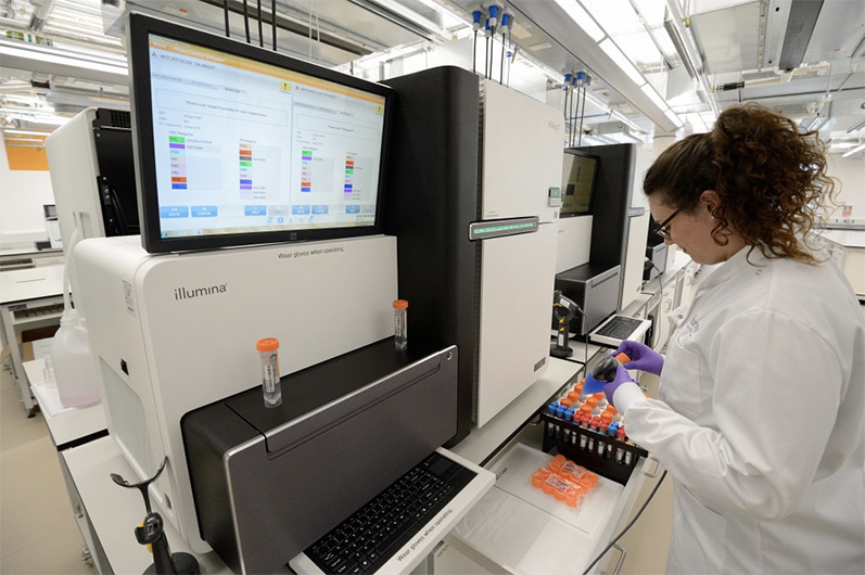 In this undated photo, a scientist loading a DNA sample onto a genome sequencing machine in Cambridge, UK. (Photo courtesy: Genomics England)