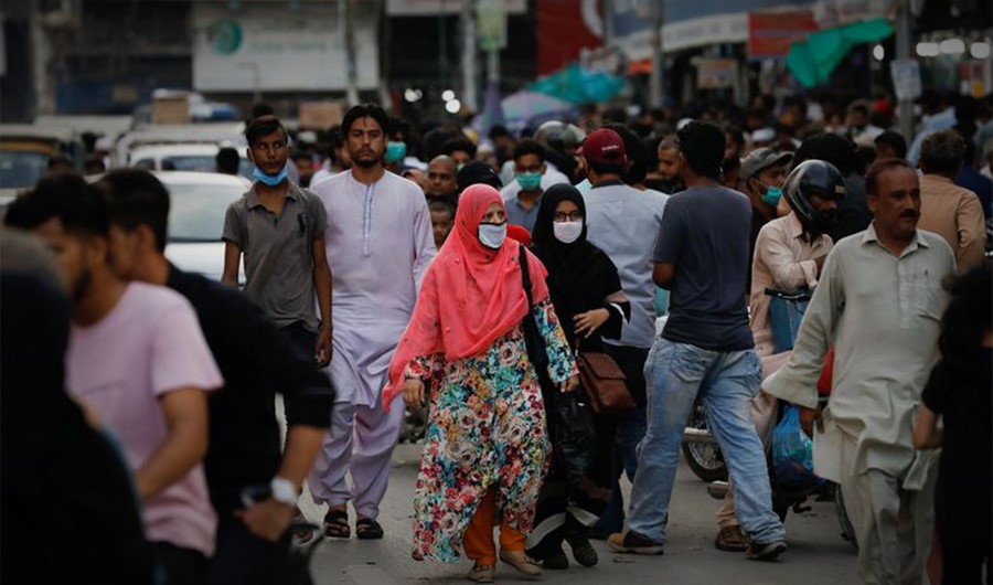 Women wearing protective face masks walk amid the rush of people along a road in Karachi, Pakistan July 20, 2020. (REUTERS)