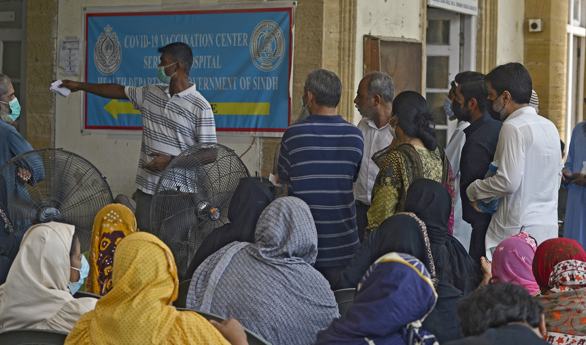 People queue up to register themselves to get inoculated with the jab of Covid-19 coronavirus vaccine at a vaccination camp held in karachi on May 22, 2021. (AFP/File)