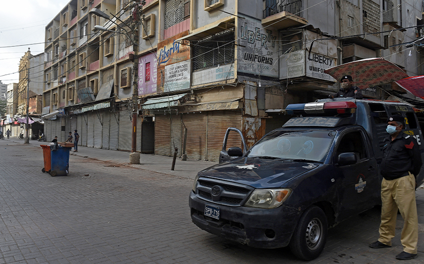 Police stand guard at a commercial market area with closed shops after the authorities imposed an evening lockdown to curb the spread of the Covid-19 in Karachi, Pakistan, on May 28, 2021. (AFP/File)