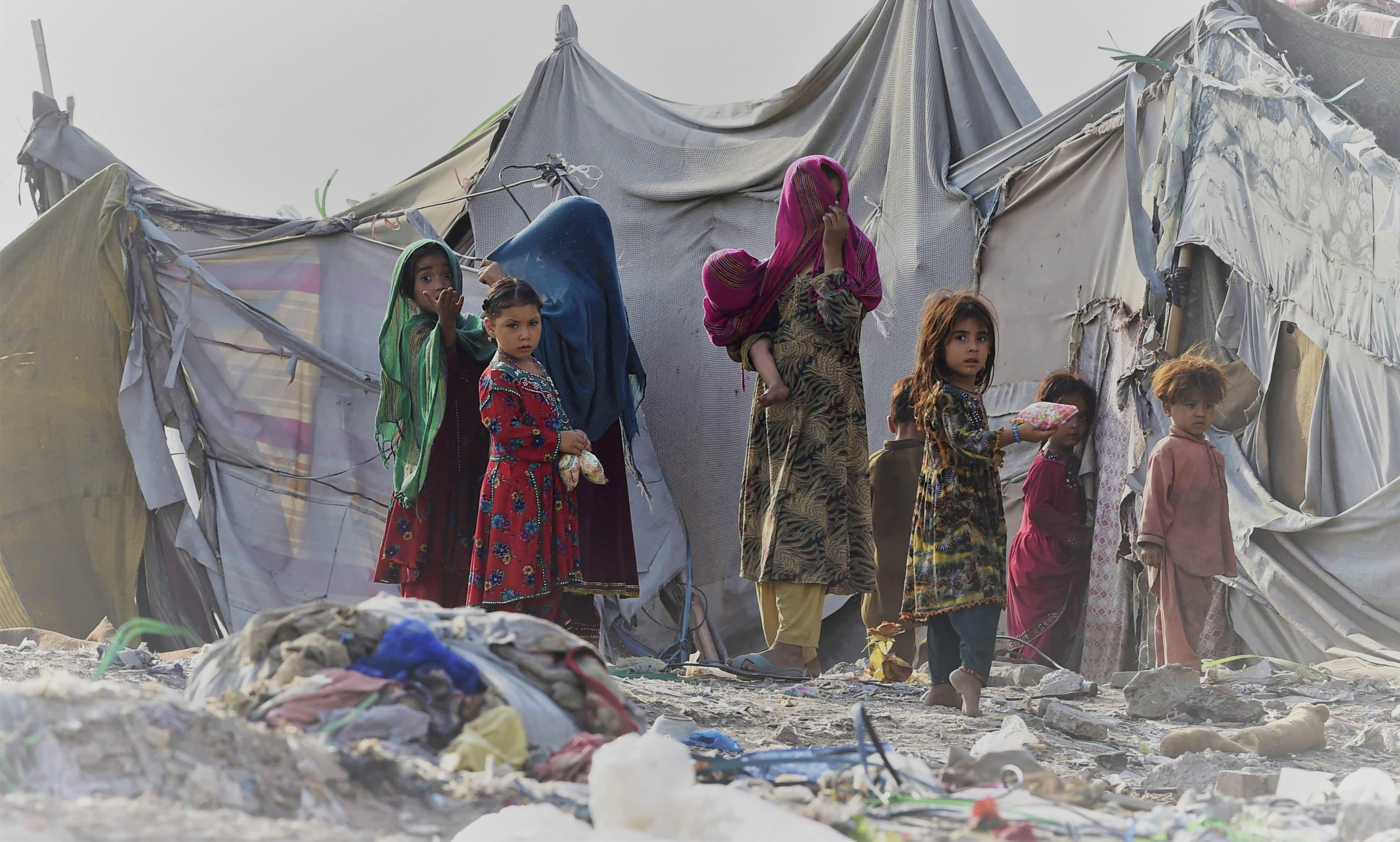 Children of Afghan refugees play outside tents in Afghan Basti area on the outskirts of Lahore on June 19, 2021. (AFP)
