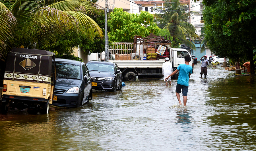 People wade through a flooded residential area following heavy monsoon rains triggered floods in Pakistan's port city of Karachi on August 31, 2020. (AFP/File)