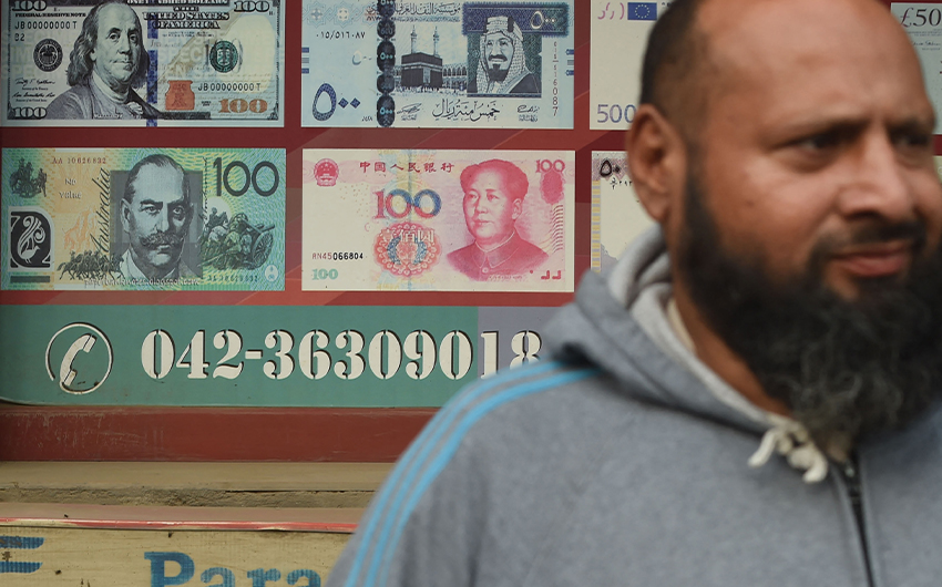 A Pakistani man walks past the currency exchange shop in Lahore, Pakistan, on January 3, 2018. (AFP/File)
