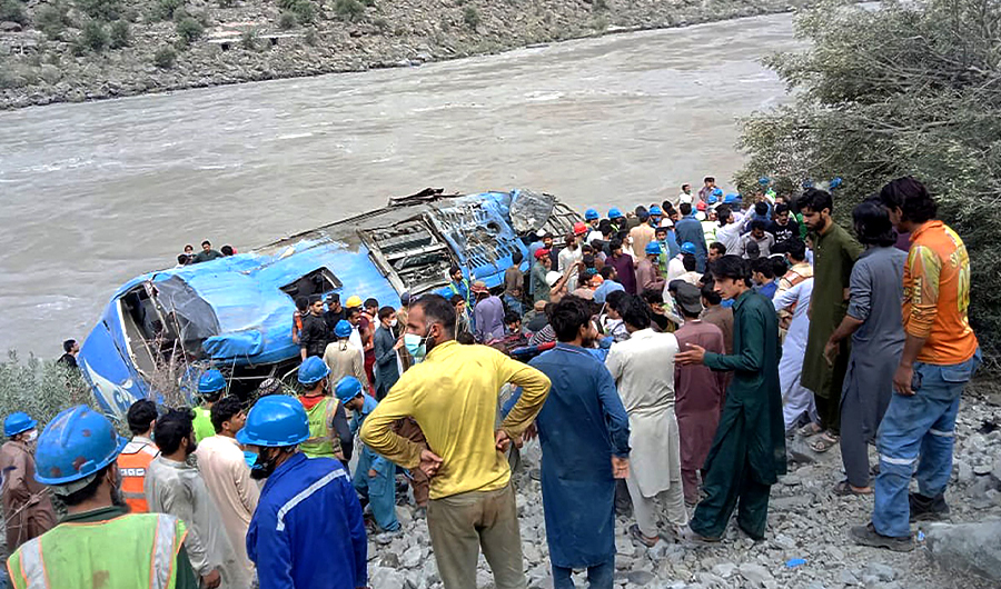 Rescue workers and onlookers gather around a wreck after a bus plunged into a ravine following a bomb explosion in Kohistan district of Khyber Pakhtunkhwa province on July 14, 2021. (AFP)