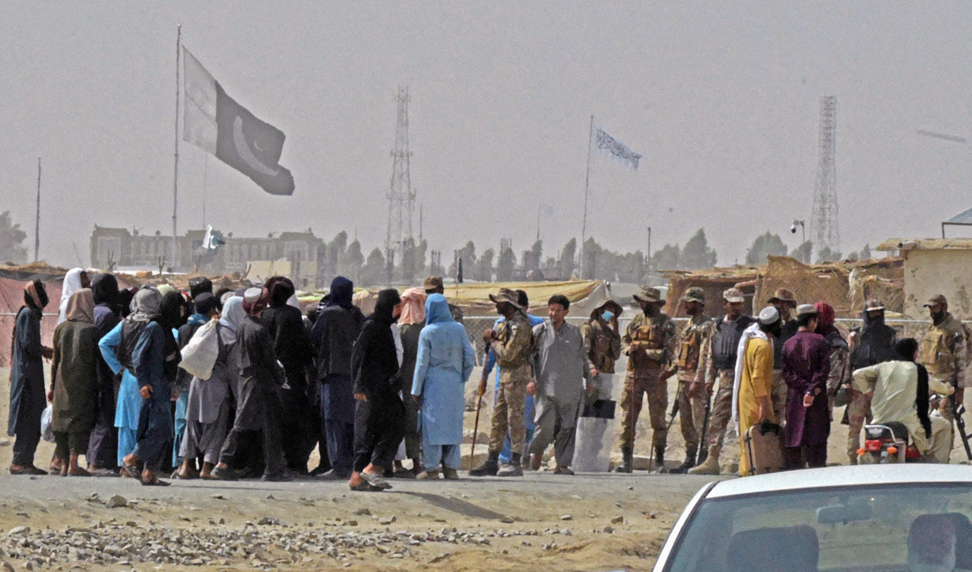 Stranded people speak Pakistani troops in the border town of Chaman on July 14, 2021, after the Taliban claimed they had captured the Afghan side of the border crossing of Spin Boldak along the frontier with Pakistan. (AFP)