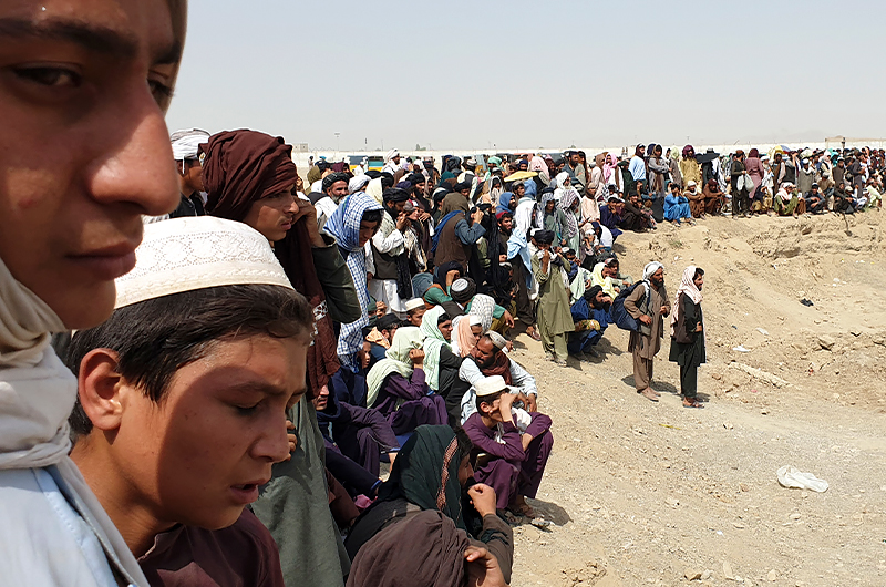 Stranded people gather near a border crossing between Afghanistan and Pakistan in Chaman on July 15, 2021. (AFP)