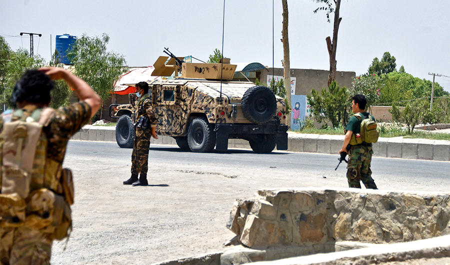 Afghan security personnel stand guard along the road amid ongoing fight between Afghan security forces and Taliban fighters in Kandahar on July 9, 2021. (AFP/File)