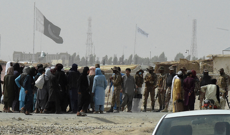 Stranded people speak Pakistani troops in the border town of Chaman on July 14, 2021. (AFP)