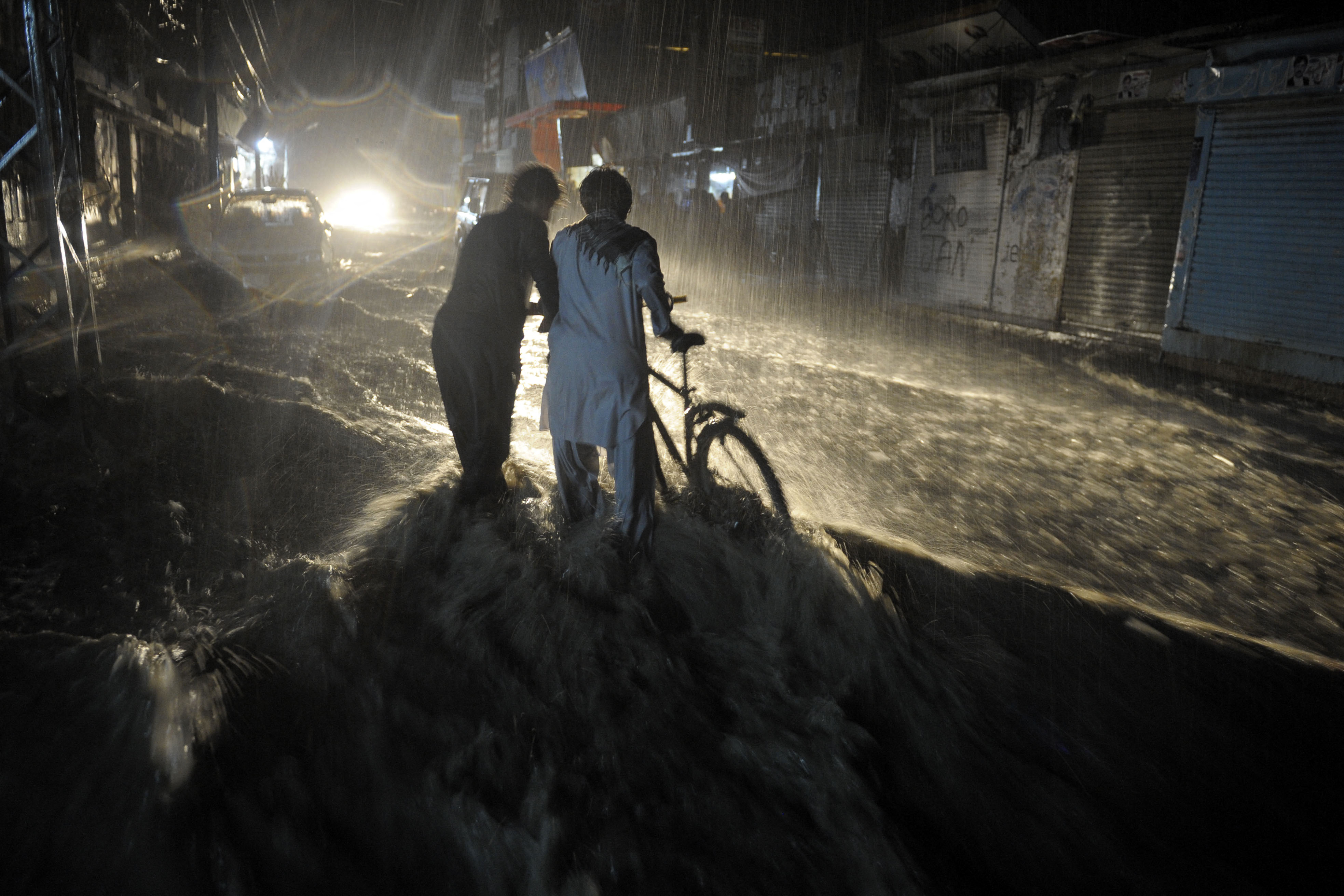 Pakistani men cross a flooded street during heavy monsoon rain in Quetta on August 6, 2013. (AFP/File)