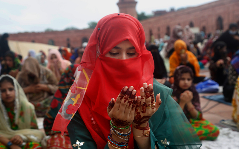 A woman attends Eid al-Adha prayers at the historical Badshahi mosque, in Lahore, Pakistan, on July 21, 2021. (AP)