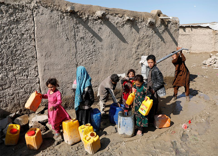 Internally displaced Afghans collect water from a public water pump next to their tents at a refugee camp, during the spread of coronavirus disease (COVID-19), in Kabul, Afghanistan March 28, 2020. (REUTERS)