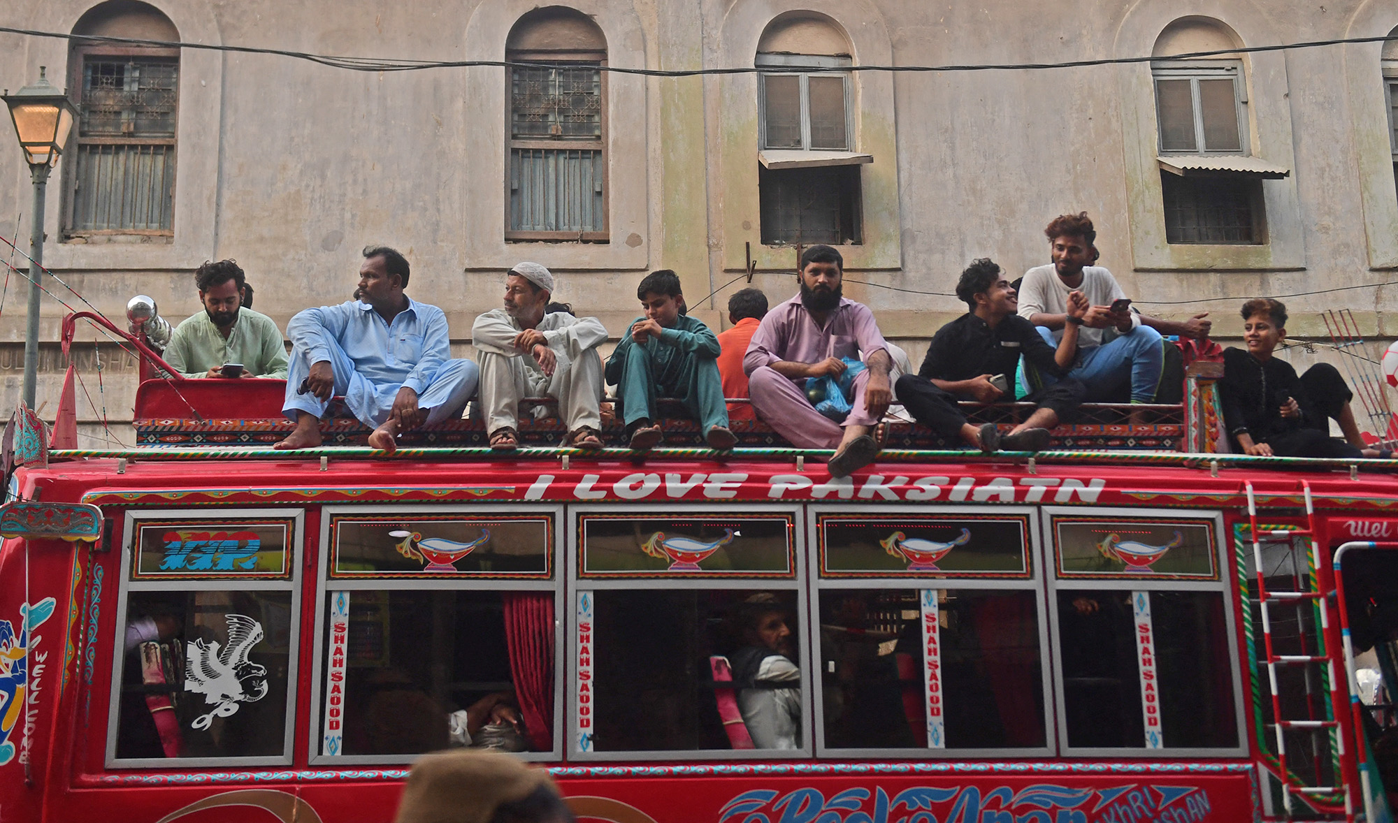 Passengers sit on a top of a mini bus amid the Covid-19 coronavirus pandemic in Karachi on May 25, 2021. (AFP/File)