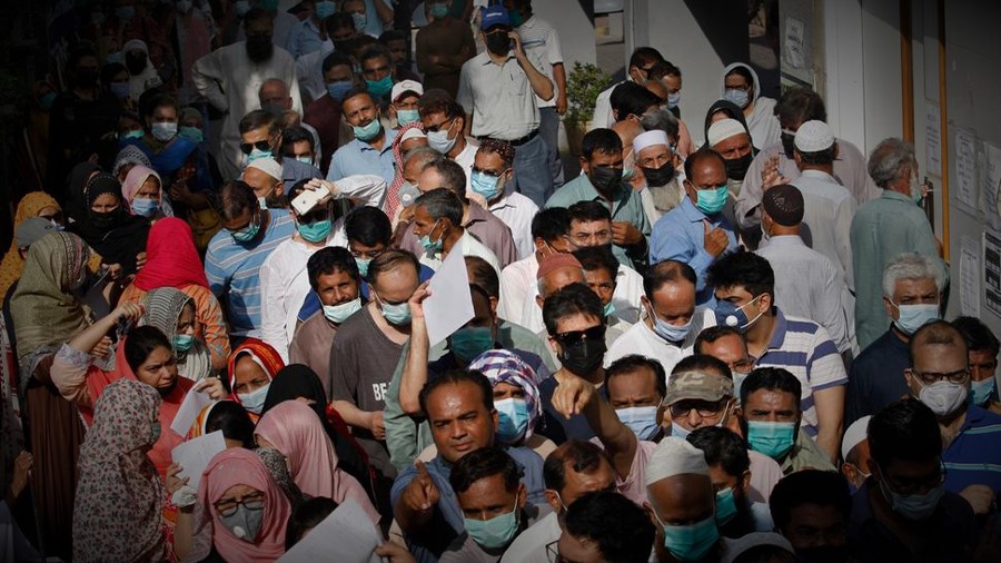 People stand in queues while they wait their turn to receive the first shot of the Sinopharm COVID-19 vaccine at a vaccination center in Karachi, Pakistan, Saturday, May 8, 2021. (AP)