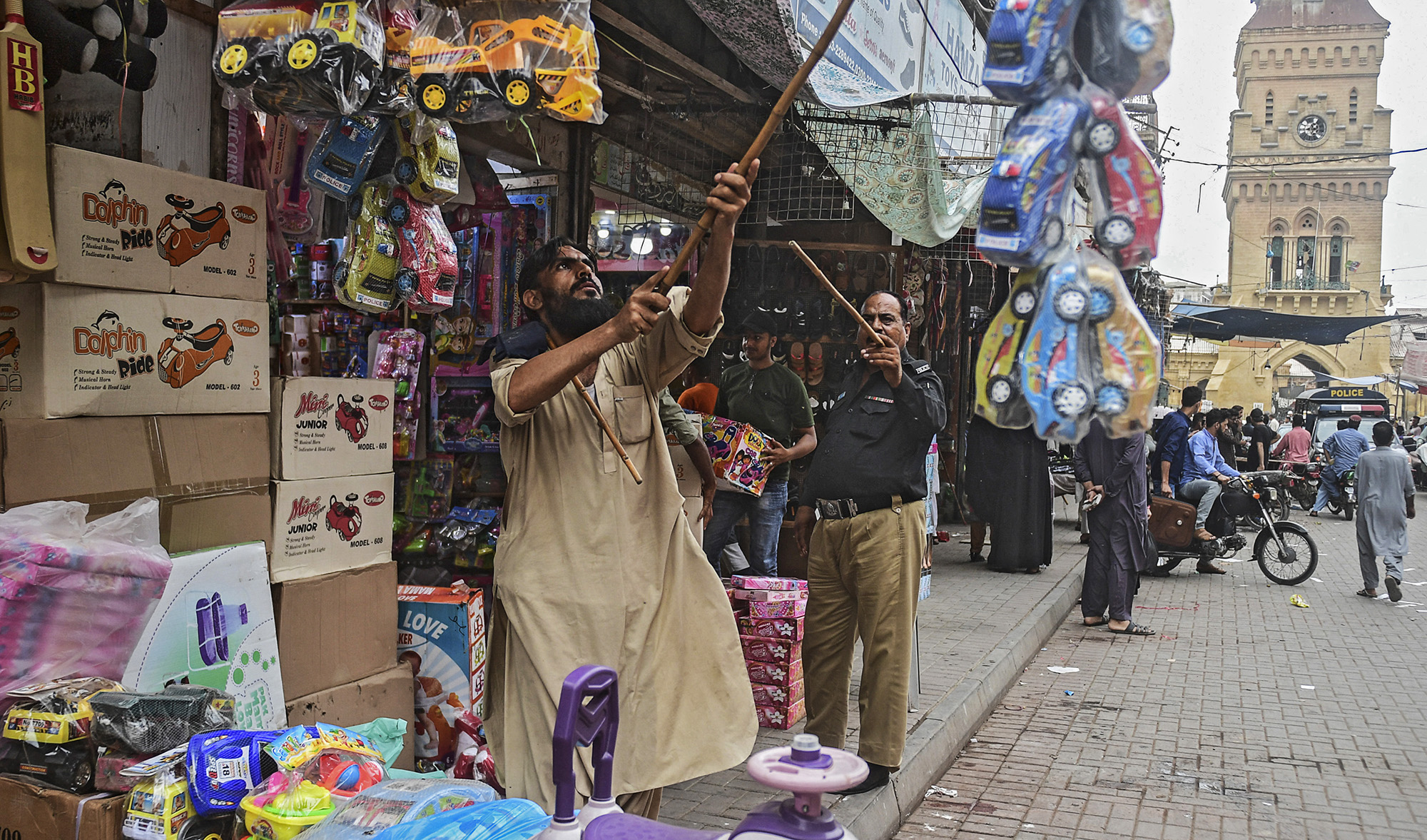 A policeman orders shopkeepers to close their shops after authorities imposed evening lockdowns amidst rising Covid-19 coronavirus cases in Karachi on July 26, 2021. (AFP)