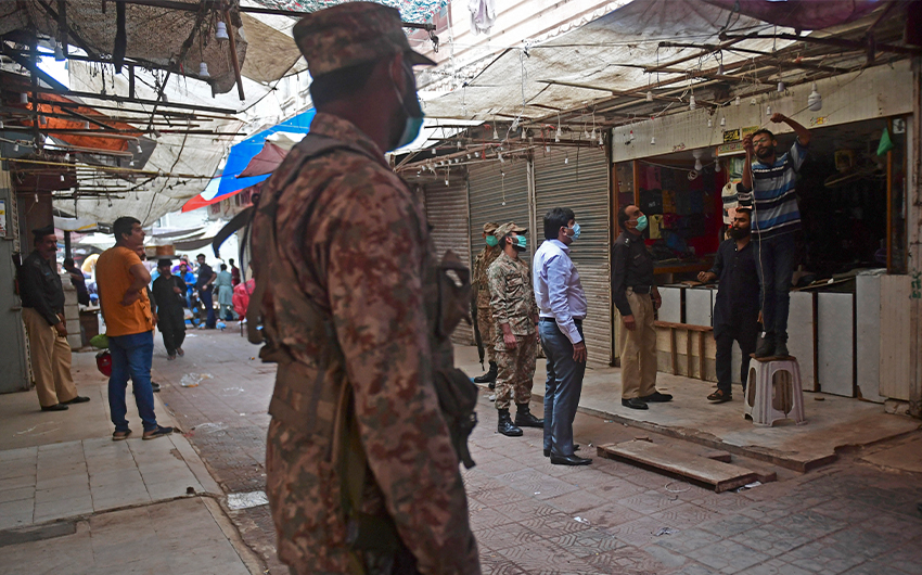 Security officials arrive at a market to enforce an evening lockdown imposed amid rising coronavirus cases in Karachi, Pakistan, on July 27, 2021. (AFP)