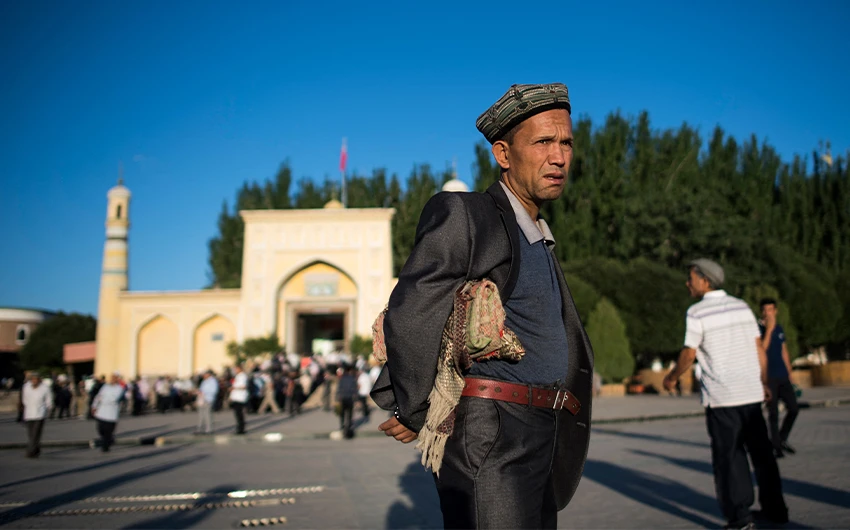 A Muslim man carrying a prayer rug as he arrives at a mosque for the morning prayer in the old town of Kashgar in China's Xinjiang on June 26, 2017. (AFP/File)