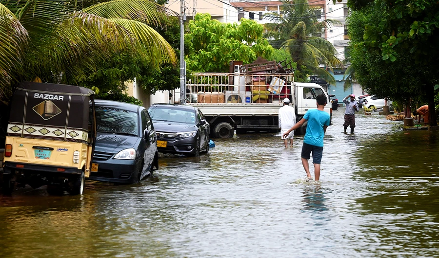 People wade through a flooded residential area following heavy monsoon rains triggered floods in Pakistan's port city of Karachi on August 31, 2020. (AFP/File)