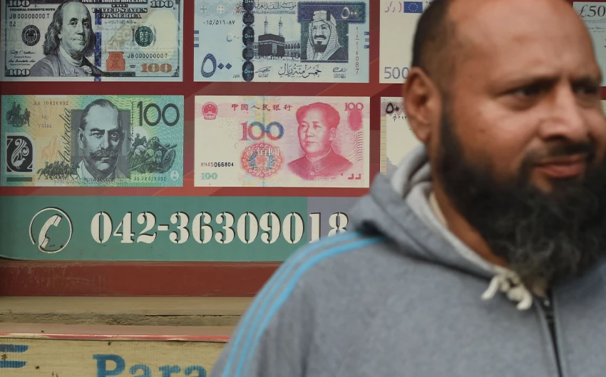 A Pakistani man walks past the currency exchange shop in Lahore, Pakistan, on January 3, 2018. (AFP/File)