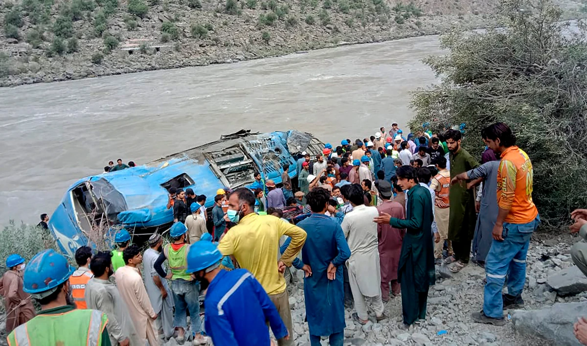 Rescue workers and onlookers gather around a wreck after a bus plunged into a ravine following a bomb explosion in Kohistan district of Khyber Pakhtunkhwa province on July 14, 2021. (AFP)