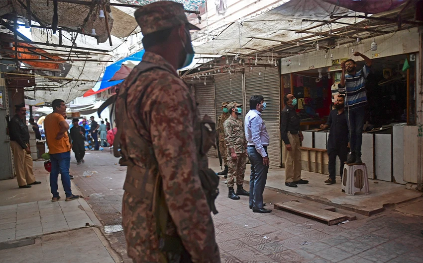 Security officials arrive at a market to enforce an evening lockdown imposed amid rising coronavirus cases in Karachi, Pakistan, on July 27, 2021. (AFP)