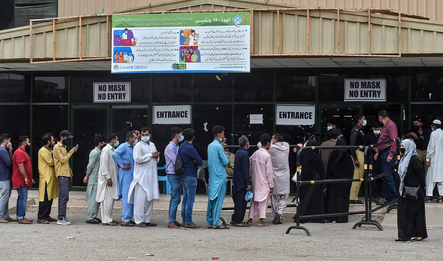 People gather in large numbers and queue up to register themselves and get inoculated with the coronavirus vaccine at a vaccination centre in Karachi, Pakistan, on July 29, 2021. (AFP)