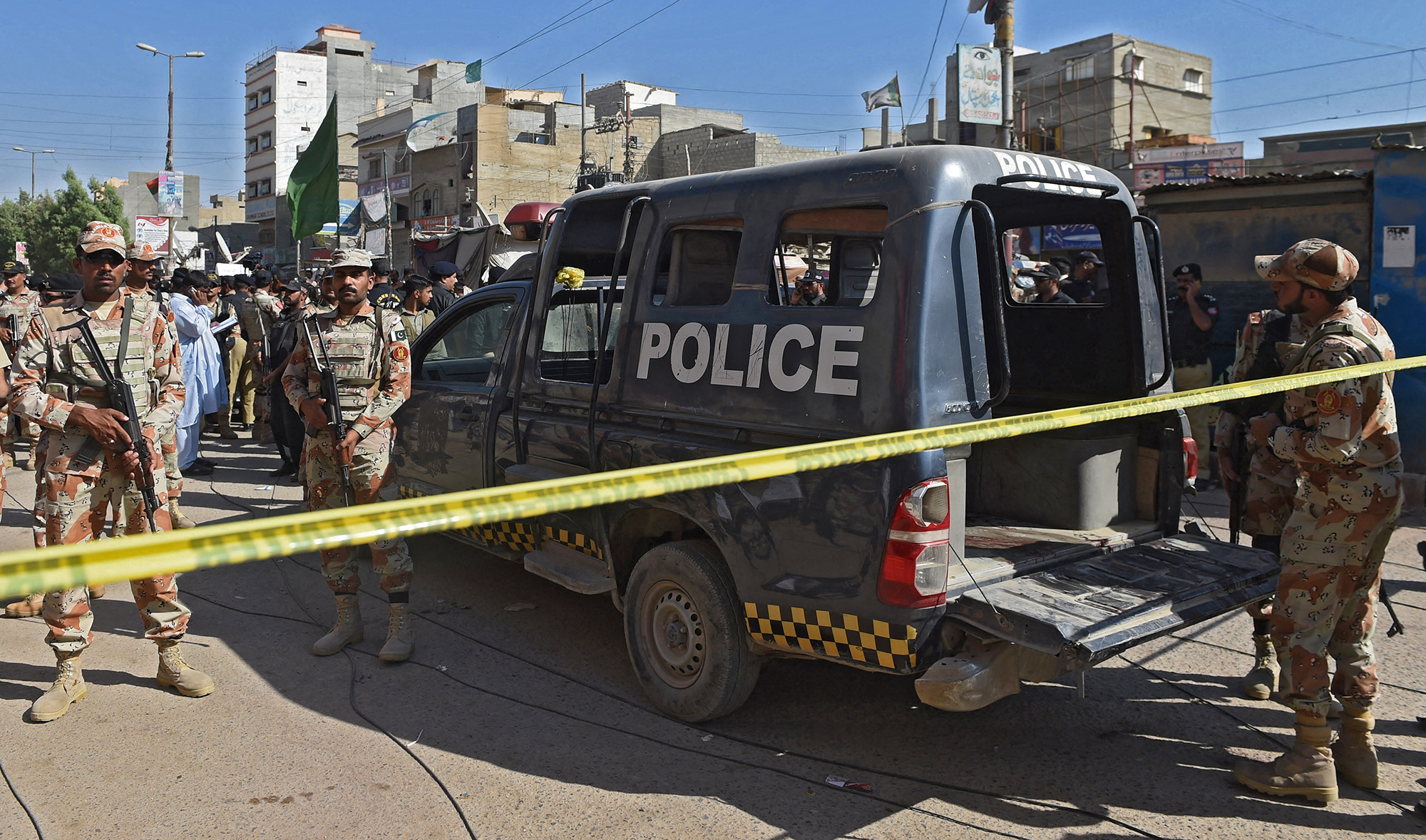 Pakistani security personnel gather around a police van after an attack by gunmen on security members guarding a polio vaccination team in Karachi on April 20, 2016. (AFP/File)