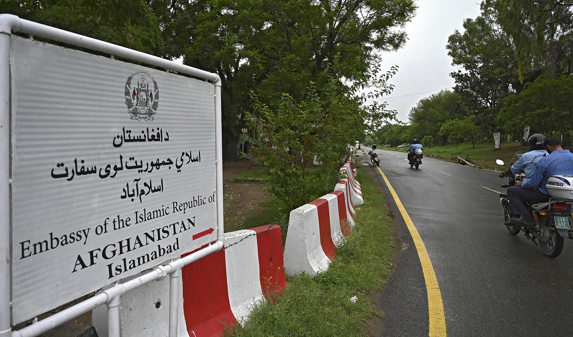 Policemen ride past the Afghan Embassy in Islamabad on July 19, 2021. (AFP)