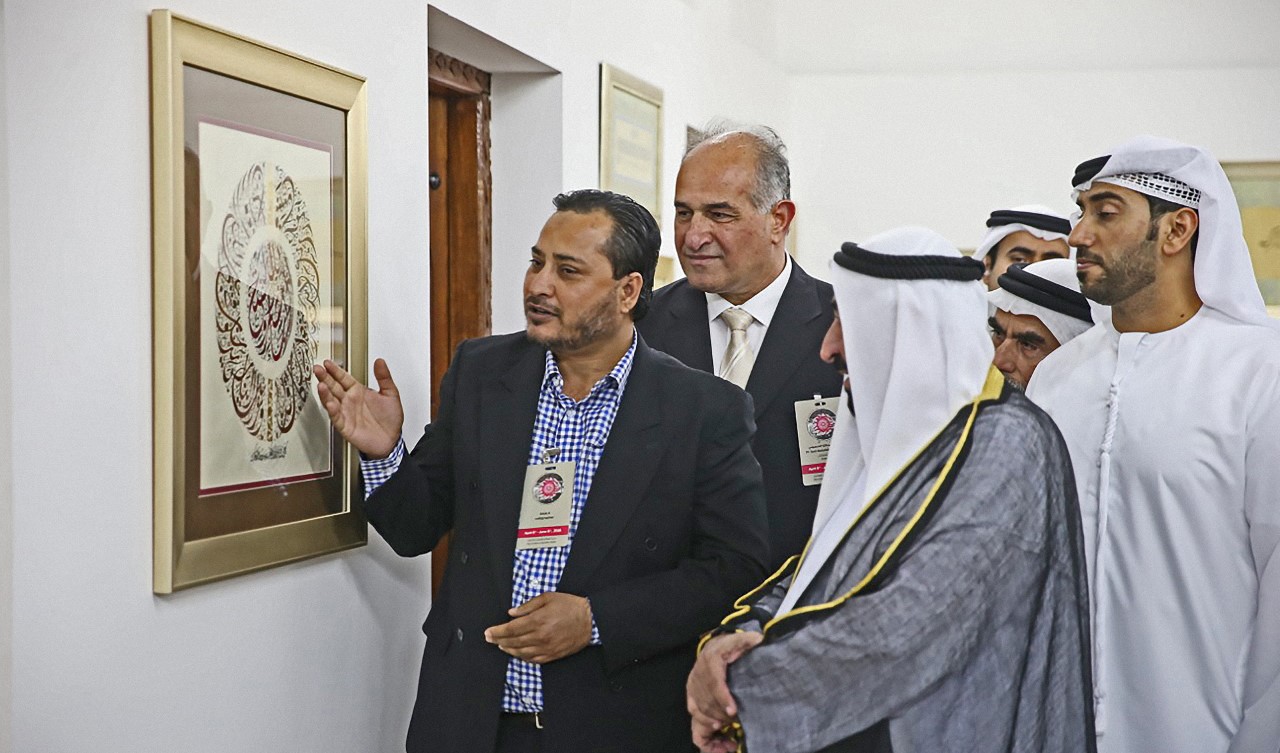 Sharjah ruler Dr. Sultan bin Muhammad Al-Qasimi looks at the work of Pakistani calligrapher and bus driver Abdul Haq during the biennial Sharjah International Calligraphy Exhibition on April 6, 2016. (AN photo)