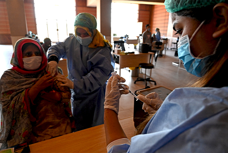 A health worker prepares to inoculate a woman with the jab of CanSino Biologics' Covid-19 coronavirus vaccine at a vaccination camp held in Islamabad on May 19, 2021. (AFP)