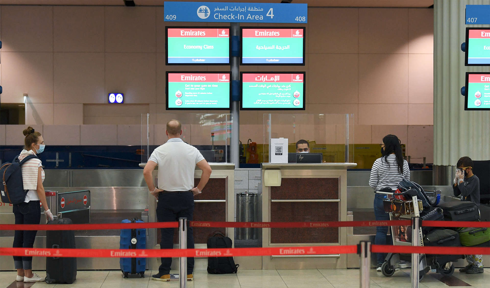 Passengers of an Emirates airlines flight check in at Dubai International Airport on May 22, 2020. (AFP/File)
