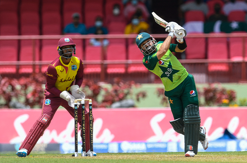 Mohammad Rizwan (R) of Pakistan hits 6 and Nicholas Pooran (L) of the West Indies looks on during the 2nd T20I match between the West Indies and Pakistan in Providence, Guyana, on July 31, 2021. (AFP)