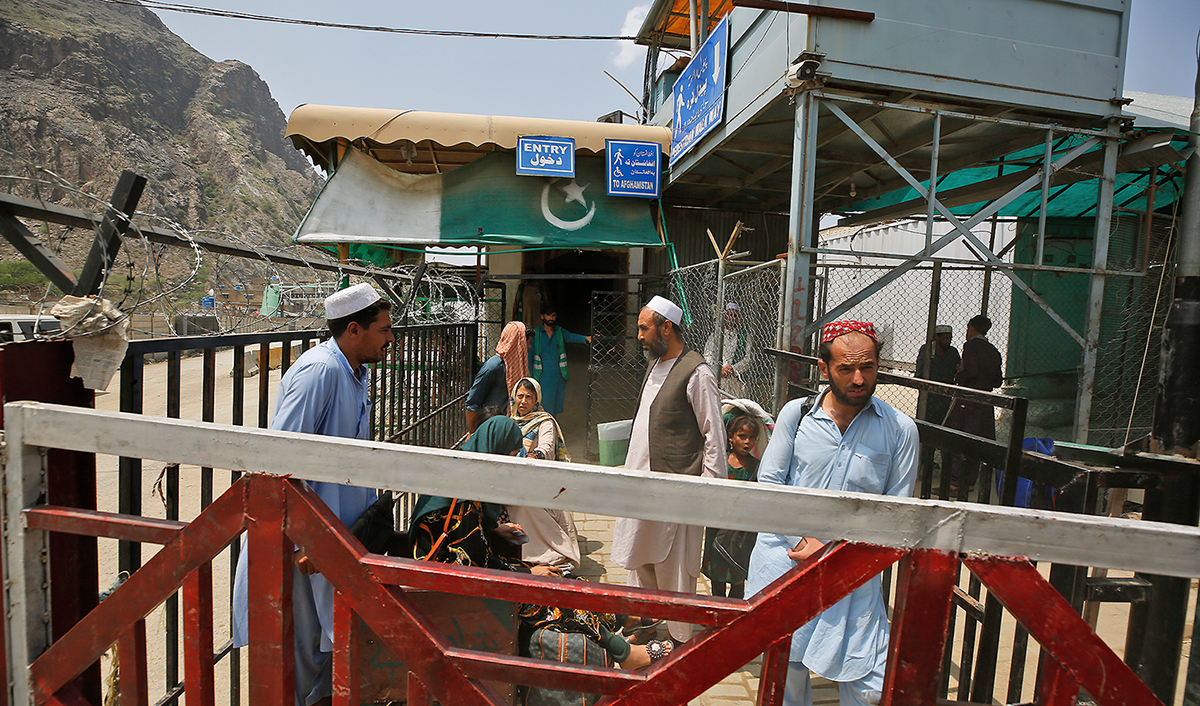 Afghan nationals wait to cross through Torkham border crossing, in Khyber district, Pakistan, on August 3, 2021. (AP)
