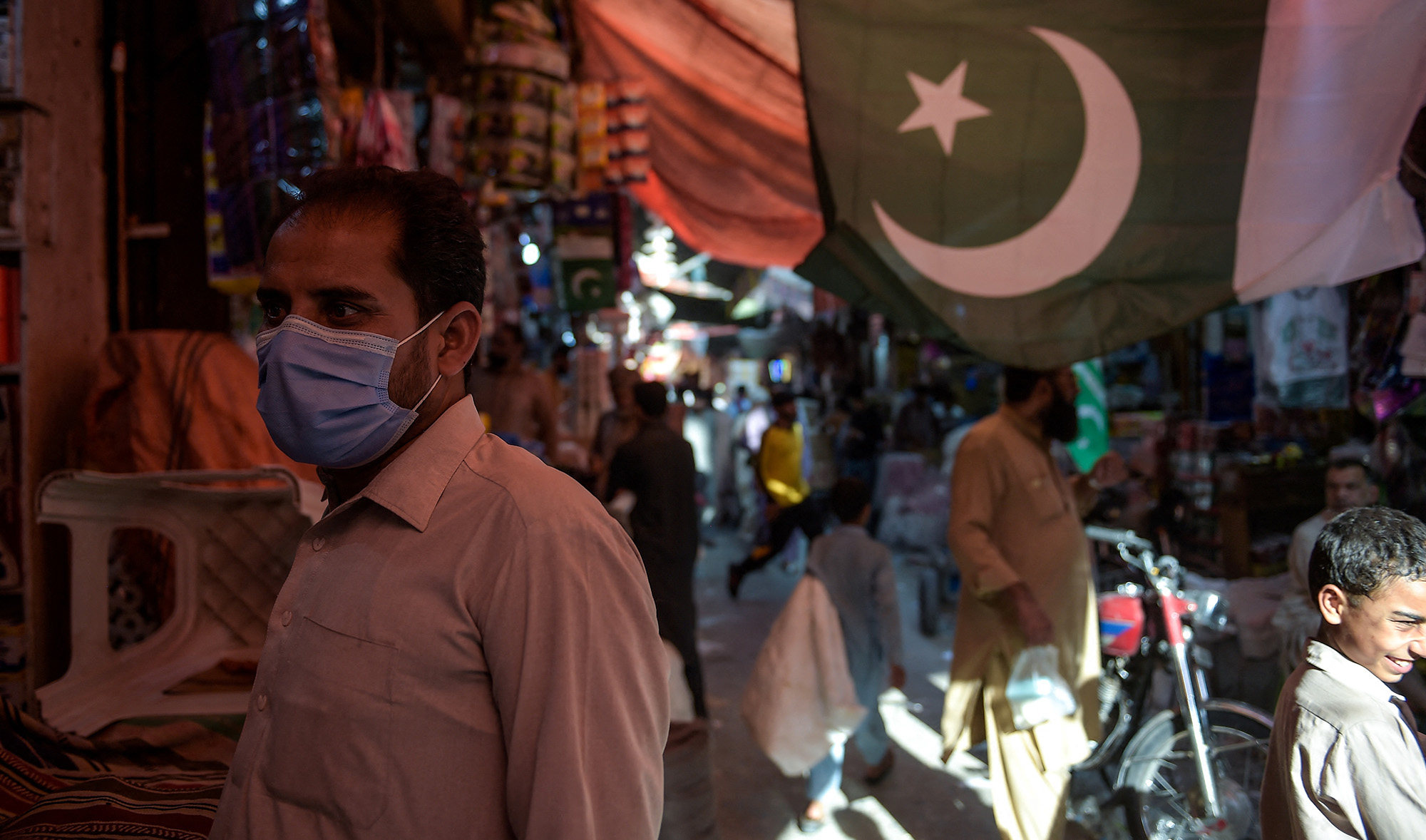 A man wearing a face mask as a preventive measure against the COVID-19 coronavirus shops at the Raja Bazar in Rawalpindi on July 22, 2020. (AFP/File)