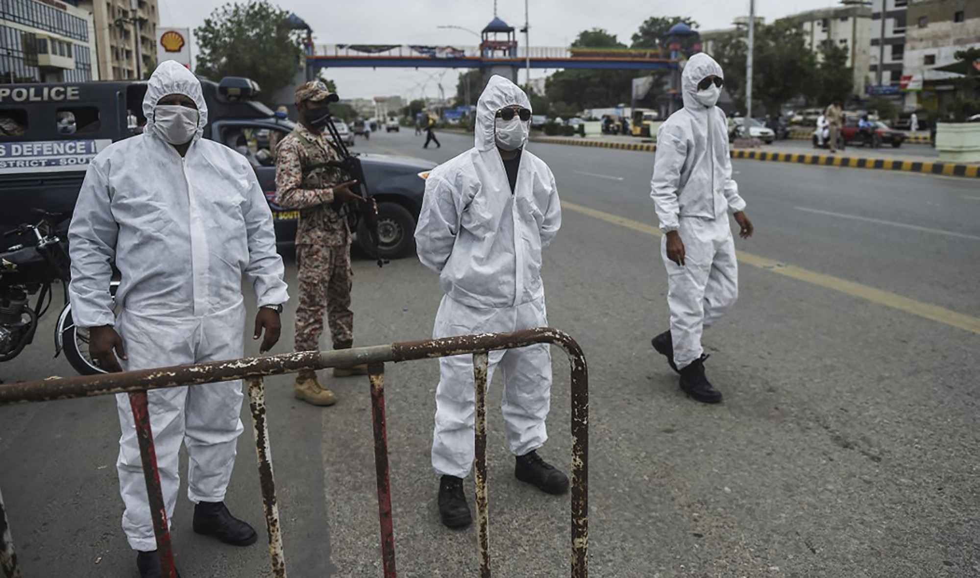 Policemen wearing personal protective equipment (PPE) stand at a security check point on a street as a partial lockdown was imposed to curb the spread of the COVID-19 coronavirus in Karachi on August 2, 2021. (AFP)
