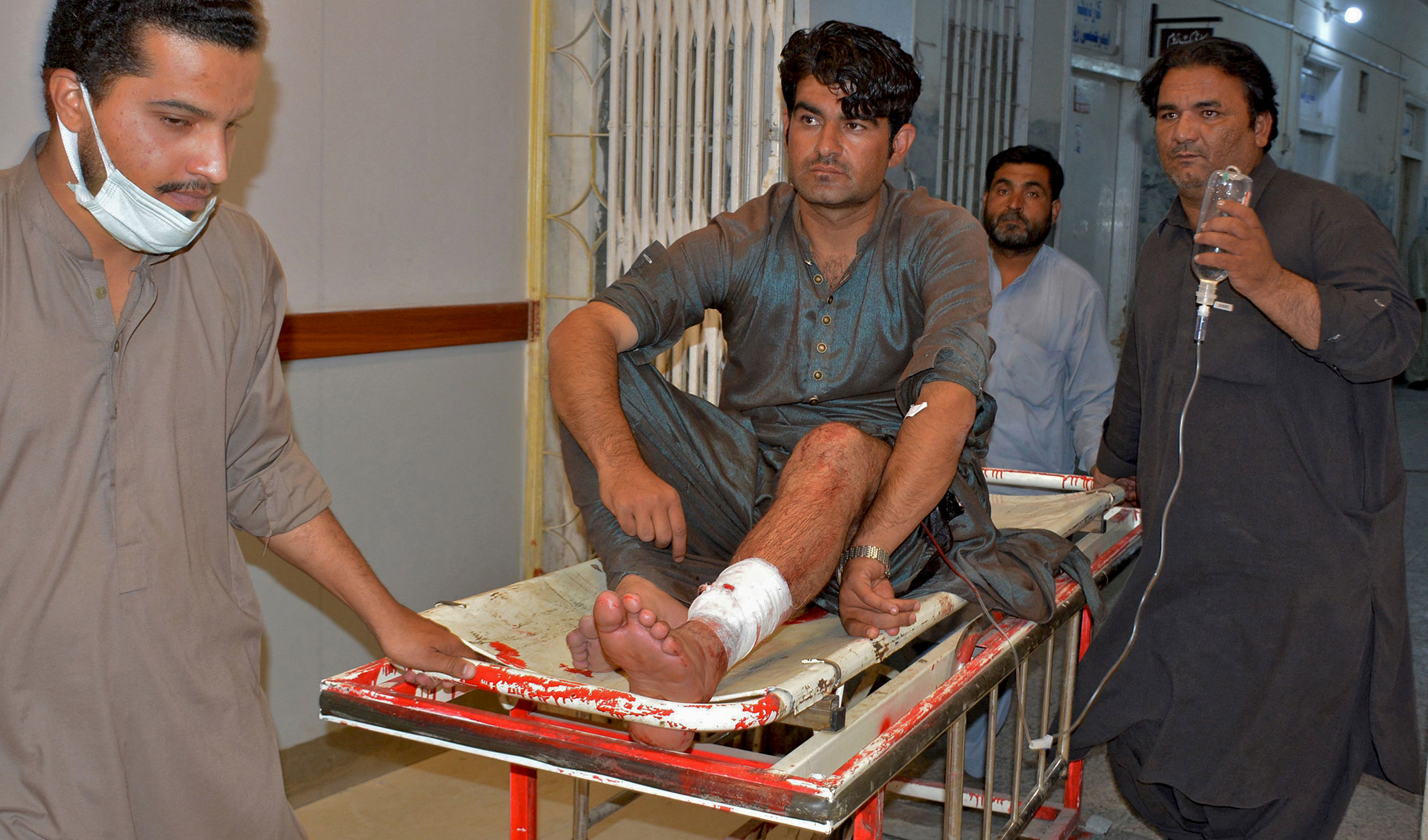 People bring a victim who was injured in a bomb explosion for treatment to a hospital in Quetta on August 8, 2021. (AFP)