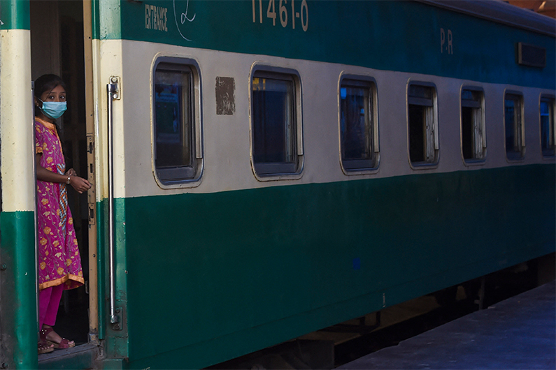 A girl boards a passenger train to Rawalpindi at a station after the government eased a lockdown imposed to prevent the spread of the COVID-19 coronavirus in Lahore on May 20, 2020. (AFP)