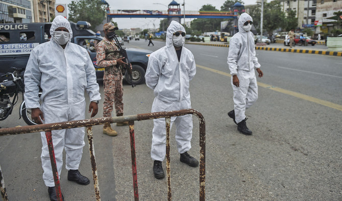 Policemen wearing personal protective equipment (PPE) stand at a security check point on a street as a partial lockdown was imposed to curb the spread of coronavirus in Karachi, Pakistan, on August 2, 2021. (AFP/File)